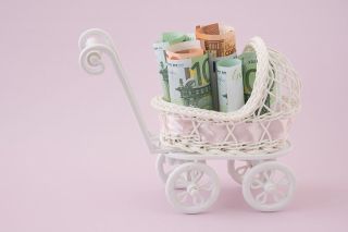 Foto: Miniaturkinderwagen mit Geldscheinen